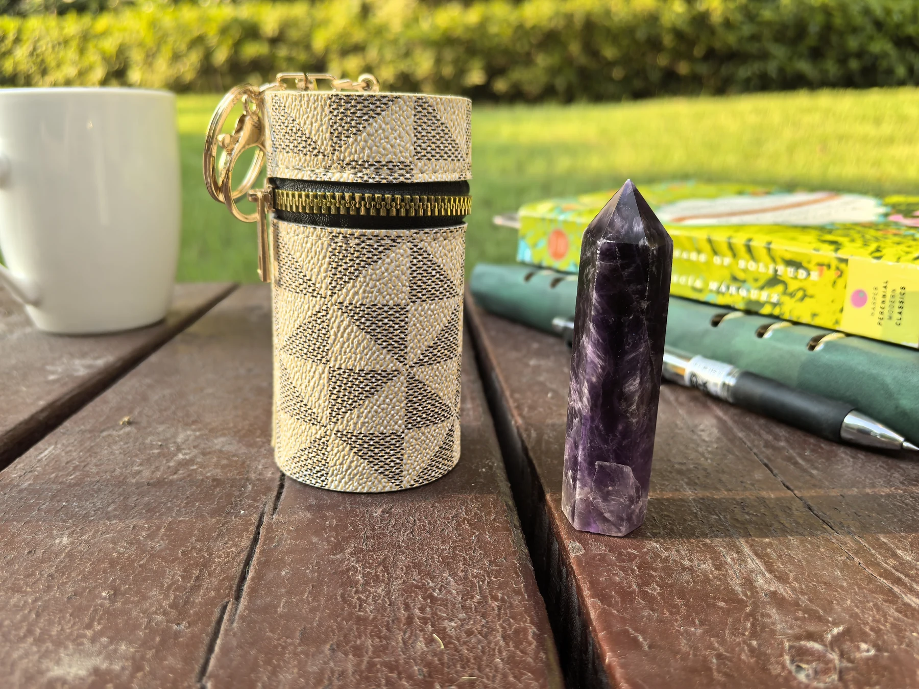 Lucurrent crystal pouch and amethyst beside an open book